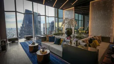 a living room with a couch and large windows at Life asoke rama 9 in Bangkok