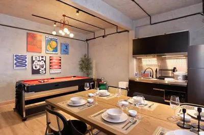 a dining room with a pool table and a kitchen at Townhouse at Sathu Pradit road in Bangkok