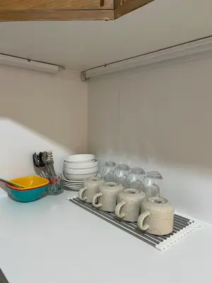 a kitchen counter with several glass jars and plates at Panoramic River View Residence in Bangkok