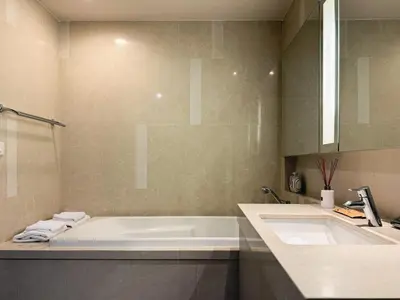 a bathroom with a bath tub and a sink at Near BTS - High Floor - Pool and Gym - Sontana in Bangkok