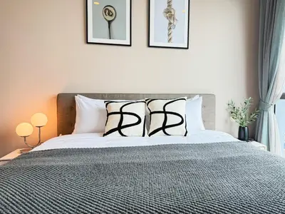 a bedroom with a bed with black and white pillows at Near BTS - High Floor - Pool and Gym - Sontana in Bangkok
