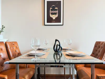 a dining table with glasses and a pair of scissors on it at Near BTS - High Floor - Pool and Gym - Sontana in Bangkok
