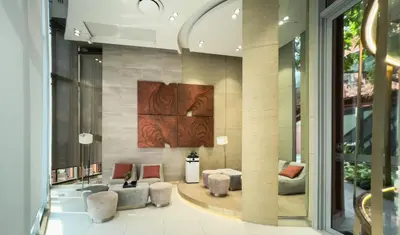 a lobby with couches and chairs in a building at Near BTS - High-Floor - Rooftop Pool - Sontana in Bangkok