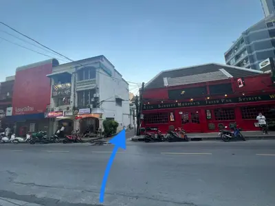 a city street with motorcycles parked in front of buildings at Ree House- Sukhumvit 23 in Bangkok