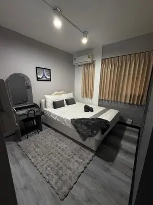 a bedroom with a bed and a chair and a table at Ree House- Sukhumvit 23 in Bangkok