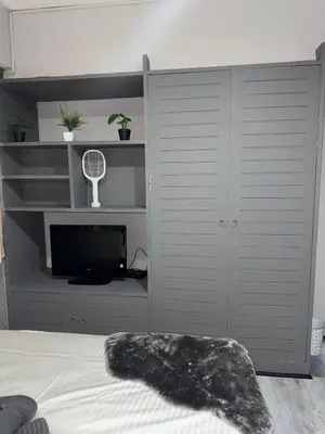 a bedroom with a bed with a tv and a closet at Ree House- Sukhumvit 23 in Bangkok