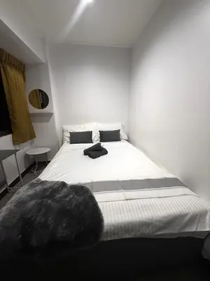 a bedroom with a white bed with a black pillow on it at Ree House- Sukhumvit 23 in Bangkok