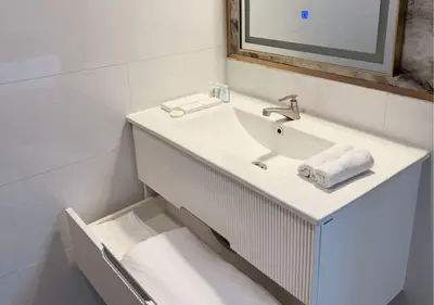 a white bathroom with a sink and a mirror at Solumie Boutique Hotel in Bangkok