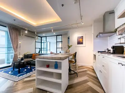 a kitchen and living room with a counter and a table at Prime Chidlom 50sqm l Large Kitchen l Walk to BTS l Wifi in Bangkok