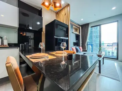 a kitchen with a dining table and a living room at Near MRT l Modern 2BR l Pool and Gym l Sontana in Bangkok