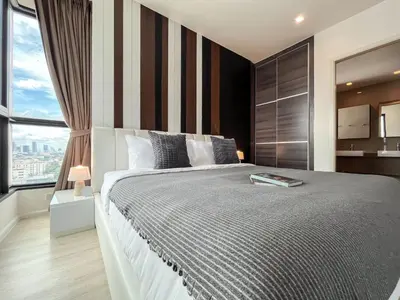 a bedroom with a large bed and a large window at Near MRT l Modern 2BR l Pool and Gym l Sontana in Bangkok