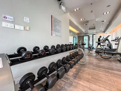 a gym with rows of dumbbells on a wall at Near MRT l Modern 2BR l Pool and Gym l Sontana in Bangkok