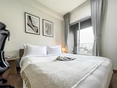 a bedroom with a large white bed with a window at Prime Sukhumvit Living - BTS Phrom Phong - Ultra Fast WiFi in Bangkok