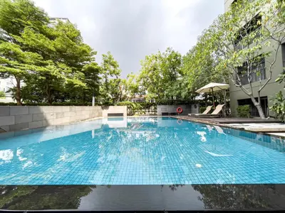 a large blue swimming pool in a building at Prime Sukhumvit Living - BTS Phrom Phong - Ultra Fast WiFi in Bangkok