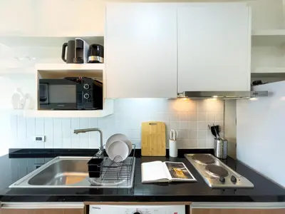 a kitchen with white cabinets and a sink at Prime Sukhumvit Living - BTS Phrom Phong - Ultra Fast WiFi in Bangkok
