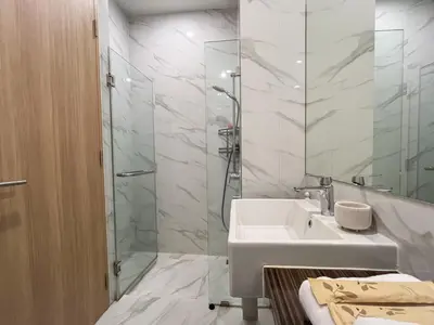 a white bathroom with a sink and a shower at Asoke Luxury High Rise - Steps to BTS and MRT - WiFi in Bangkok