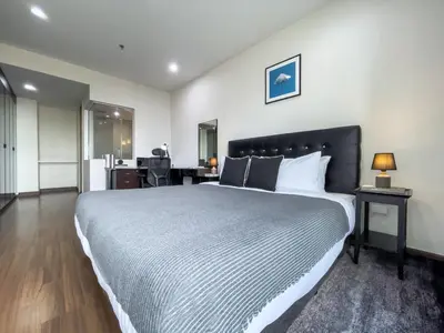 a bedroom with a large bed and a desk at Downtown Stay 65 sqm - Ultra-WiFi - BTS Ratchathewi in Bangkok