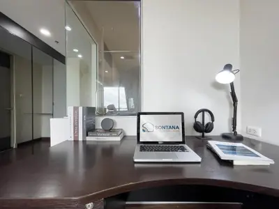 a laptop computer sitting on top of a wooden desk at Downtown Stay 65 sqm - Ultra-WiFi - BTS Ratchathewi in Bangkok