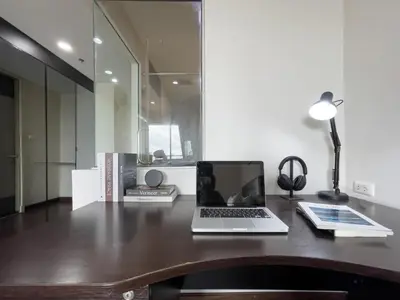 a laptop computer sitting on a desk with a lamp at Downtown Stay 65 sqm - Ultra-WiFi - BTS Ratchathewi in Bangkok