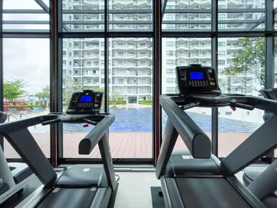 a gym with two treadmills in front of a window at Downtown Stay 65 sqm - Ultra-WiFi - BTS Ratchathewi in Bangkok