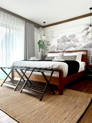 a bedroom with a large bed with a wooden frame at Thong Lo 3BR Home 75in SmartTV Netflix - Quiet Home in the City Center in Bangkok