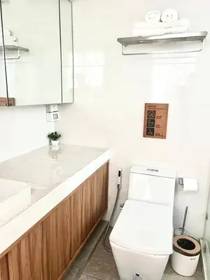 a white bathroom with a toilet and a sink at Thong Lo 3BR Home 75in SmartTV Netflix - Quiet Home in the City Center in Bangkok