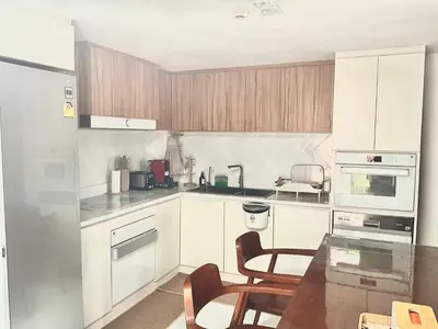 a kitchen with white cabinets and a table with chairs at Thong Lo 3BR Home 75in SmartTV Netflix - Quiet Home in the City Center in Bangkok