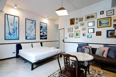 a bedroom with a bed and a table and pictures at XX The Character Yaowarat-ตรอกข้าวสาร in Samphanthawong