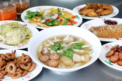 a table with bowls of soup and plates of food at XX The Character Yaowarat-ตรอกข้าวสาร in Samphanthawong