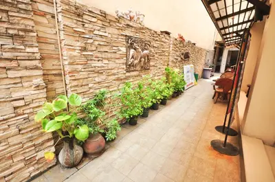 a brick wall with a row of potted plants at At Home Guest House in Bangkok
