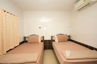two beds in a small room with aermottermottermott at At Home Guest House in Bangkok
