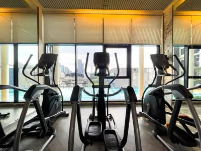 a gym with several cardio machines in front of a window at 150 m to MRT l Workspace and Kitchen l Suana l Sontana in Bangkok