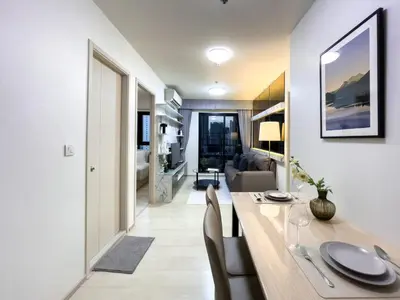 a dining room and living room with a table and chairs at 150 m to MRT l Workspace and Kitchen l Suana l Sontana in Bangkok