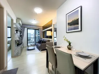 a dining room and living room with a table and chairs at 150 m to MRT l Workspace and Kitchen l Suana l Sontana in Bangkok
