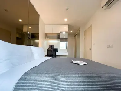 a bedroom with a large bed with a book on it at 150 m to MRT l Workspace and Kitchen l Suana l Sontana in Bangkok