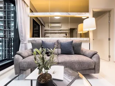 a living room with a couch and a glass table at 150 m to MRT l Workspace and Kitchen l Suana l Sontana in Bangkok