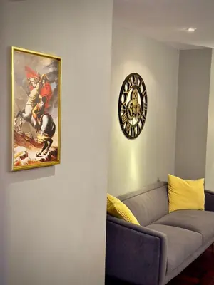 a living room with a couch and a clock on the wall at Omni Tower Sukhumvit Nana - Luxury Condominium in Bangkok