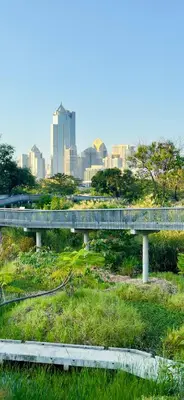 a bridge over a river with a city in the background at Omni Tower Sukhumvit Nana - Luxury Condominium in Bangkok