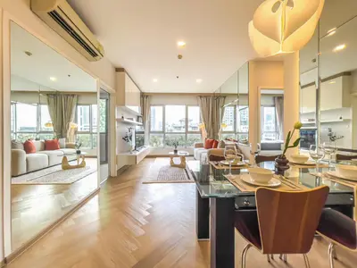 a living room with a dining table and a couch at Elegant Stay near IconSiam l High-speed WiFi l BTS Wongwian Yai in Bangkok
