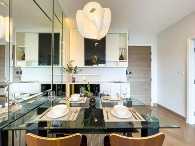 a dining room with a glass table and chairs at Elegant Stay near IconSiam l High-speed WiFi l BTS Wongwian Yai in Bangkok