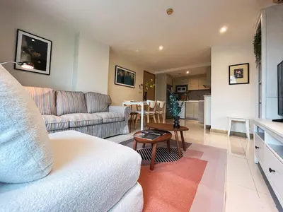 a living room with a couch and a table at Vibe Sukhumvit 61 l Ultra WIFI l Walk to BTS Thonglor or Ekkamai in Bangkok