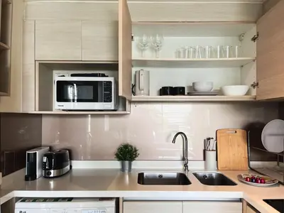 a kitchen with a sink and a microwave at Vibe Sukhumvit 61 l Ultra WIFI l Walk to BTS Thonglor or Ekkamai in Bangkok