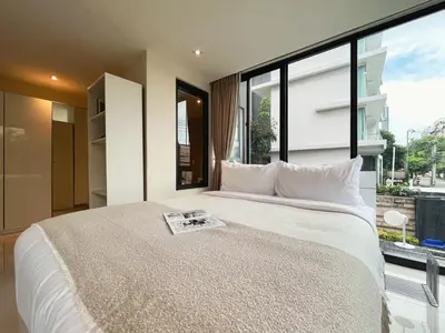 a bedroom with a large bed with a large window at Vibe Sukhumvit 61 l Ultra WIFI l Walk to BTS Thonglor or Ekkamai in Bangkok