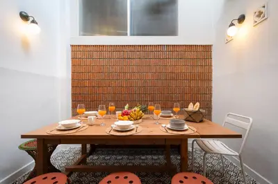 a wooden table with a bowl of fruit and wine glasses at Large BTS 10 min 2King+Twin FastWiFi SelfCheckin in Bang Rak