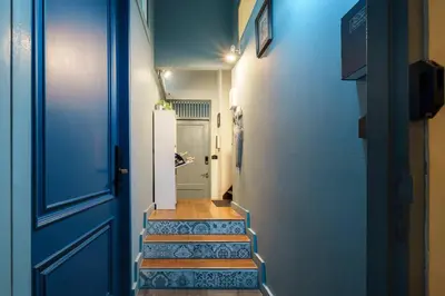 a hallway with blue walls and stairs with a blue door at Large BTS 10 min 2King+Twin FastWiFi SelfCheckin in Bang Rak