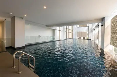 a swimming pool with water in a building at Luxury Loft with Stunning 25th Floor View in Bangkok
