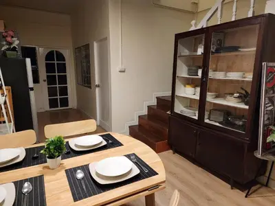 a dining room with a table and a glass cabinet at Cozy Bangkok Townhouse for 7 Guests, 5-Minute Walk from BTS in Amphoe Phra Khanong