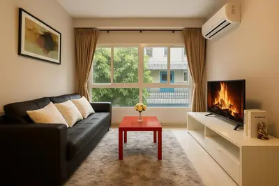 a living room with a couch and a fireplace at Cozy City Retreat in Ekkamai in Bangkok