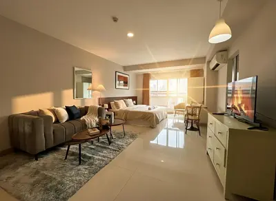a large living room with a couch and a tv at Cozy City Retreat in Ekkamai in Bangkok