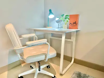 a white desk with a chair next to a table at Cozy City Retreat in Ekkamai in Bangkok